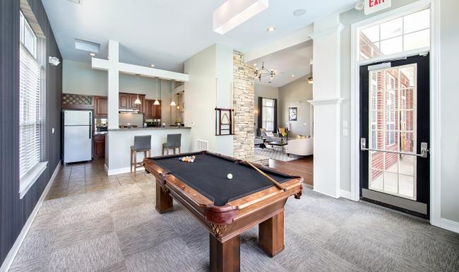 a room with a pool table and chairs